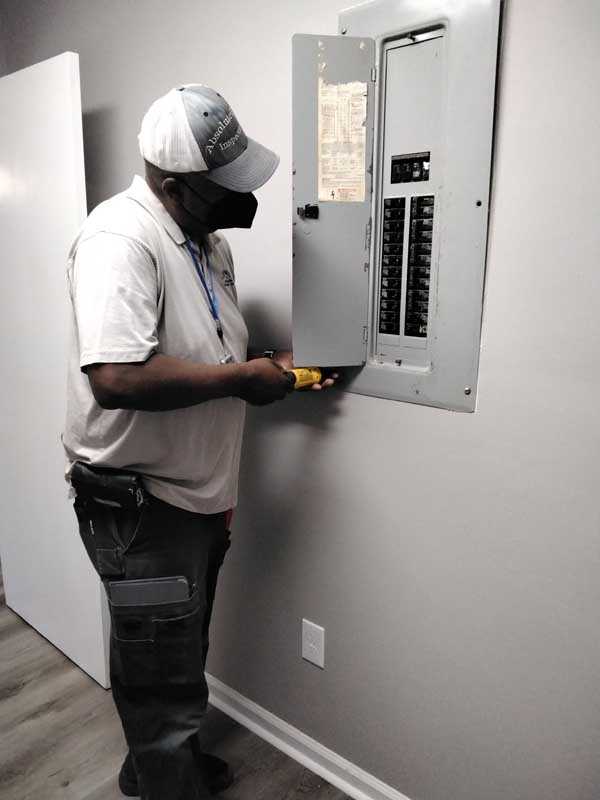 Absolute Home Inspection Service LLC inspector testing a kitchen outlet during a Jonesboro home inspection